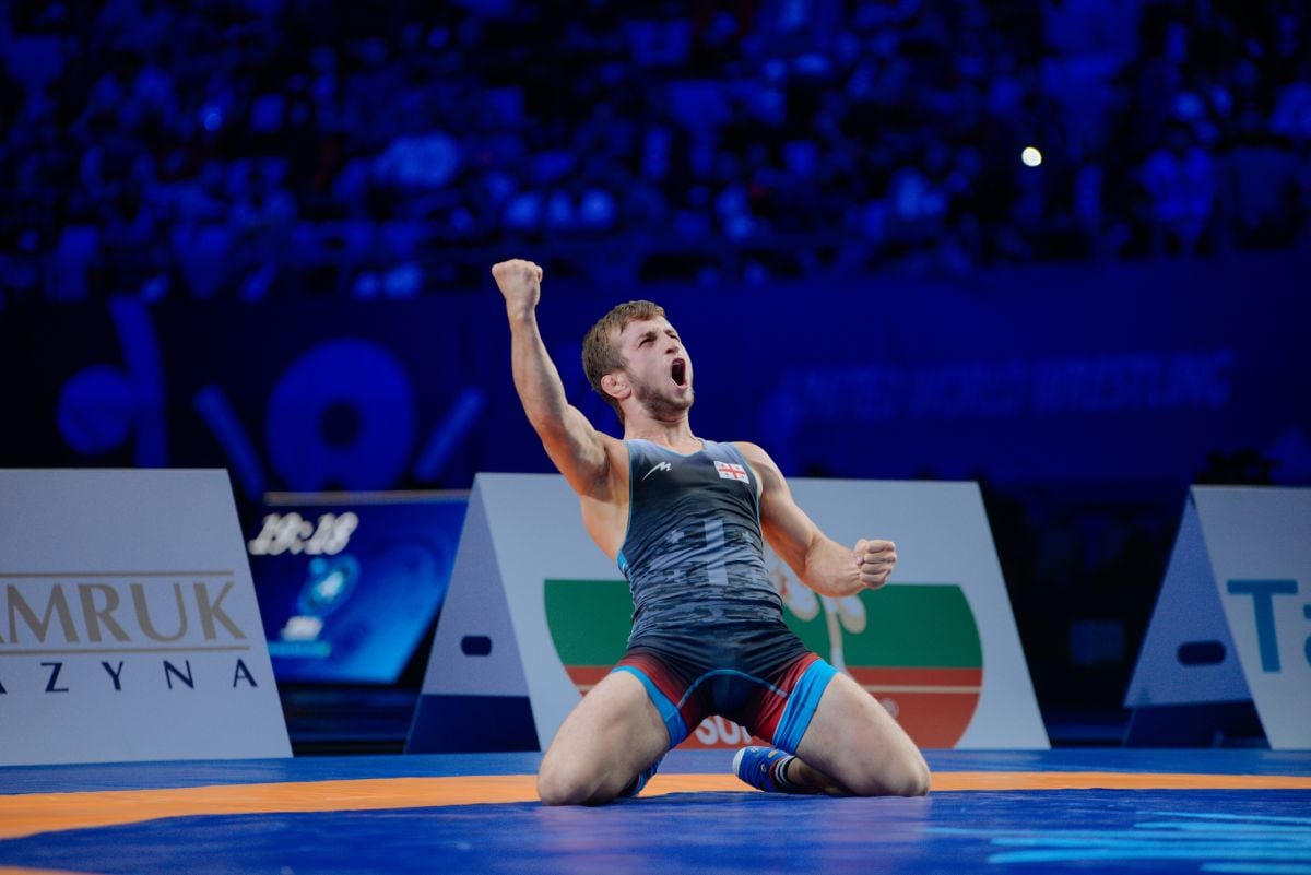 young wrestler on the mat celebrates winning