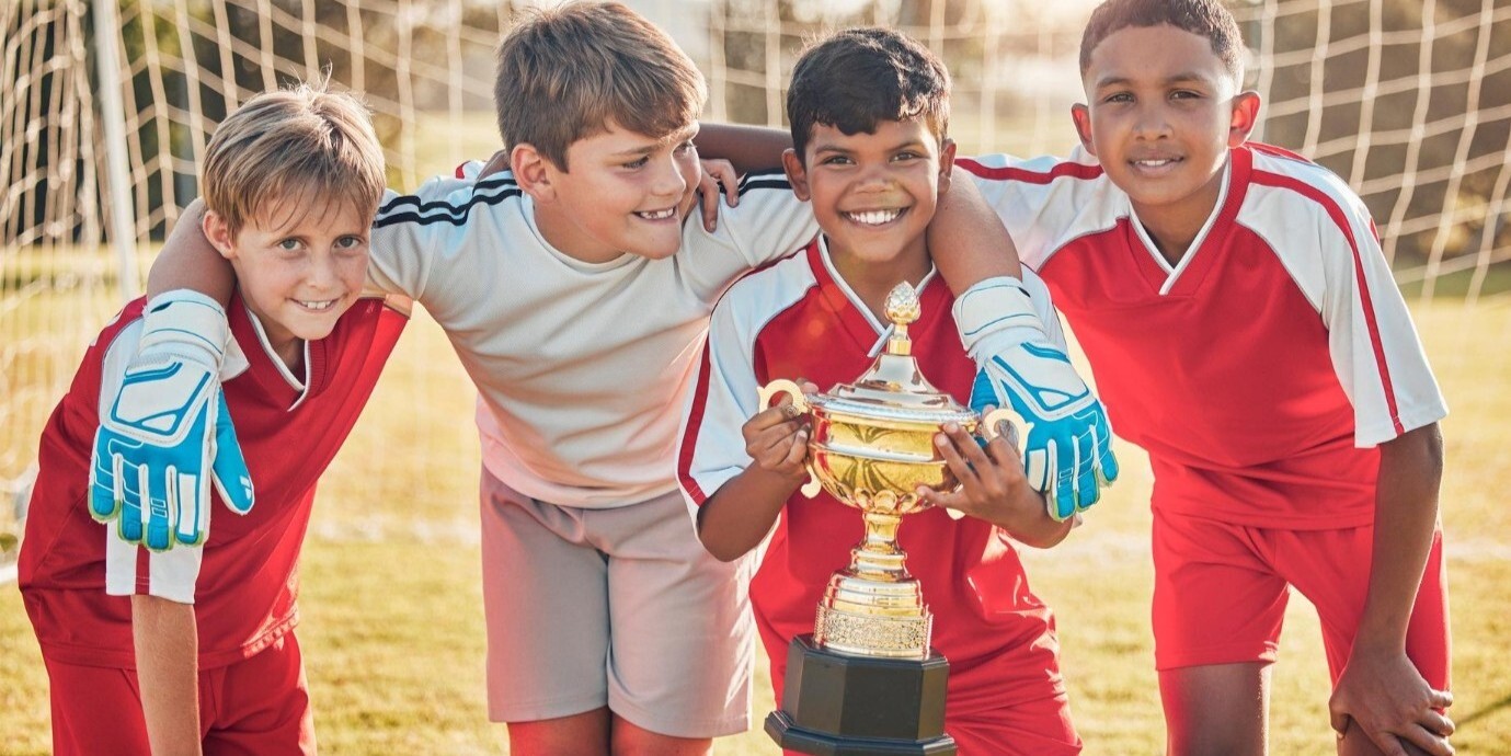 youth league soccer players with championship cup soccer trophy